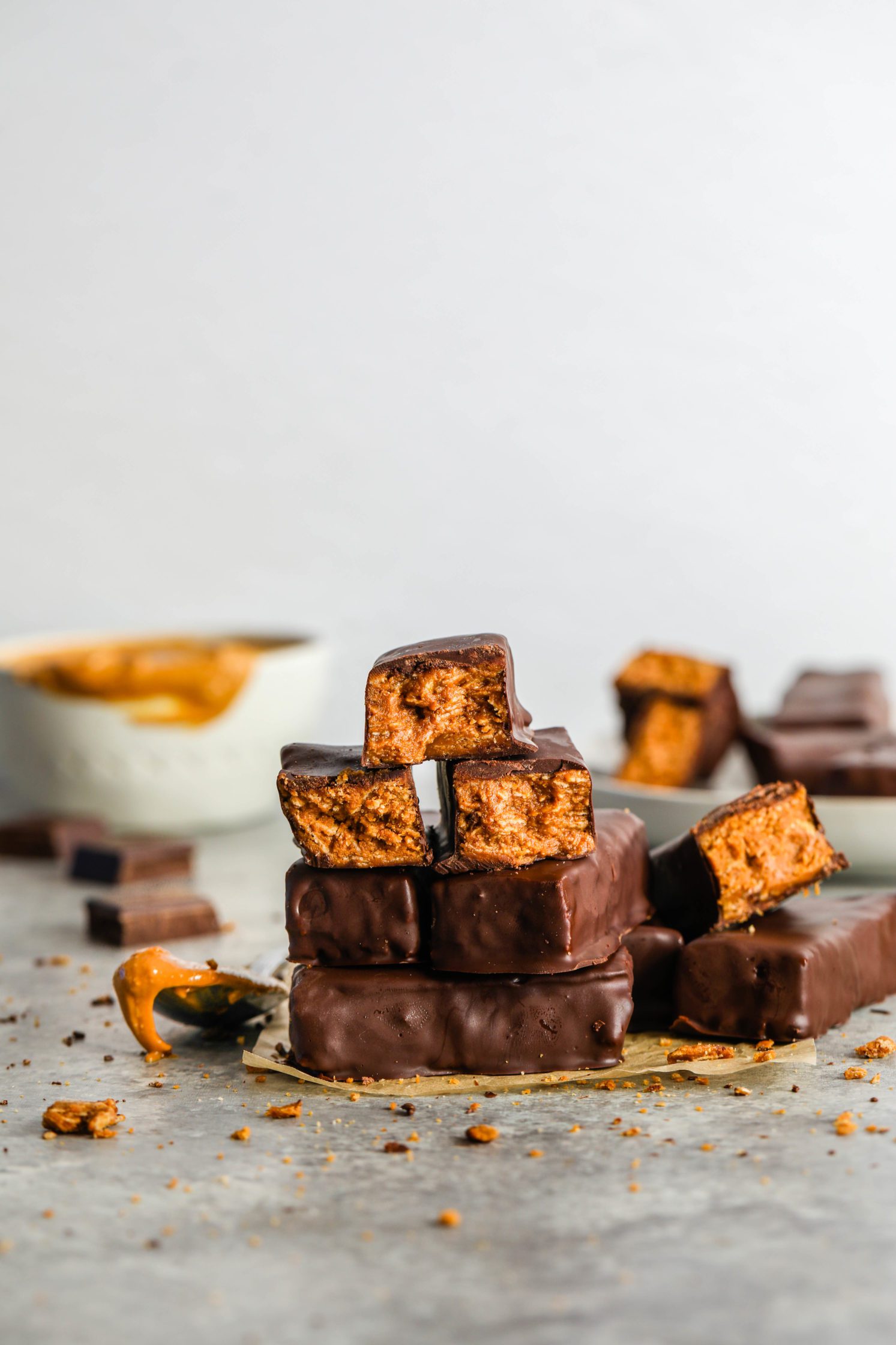 Vegan Peanut Butter Butterfingers stacked and cut open on parchment paper by Flora & Vino