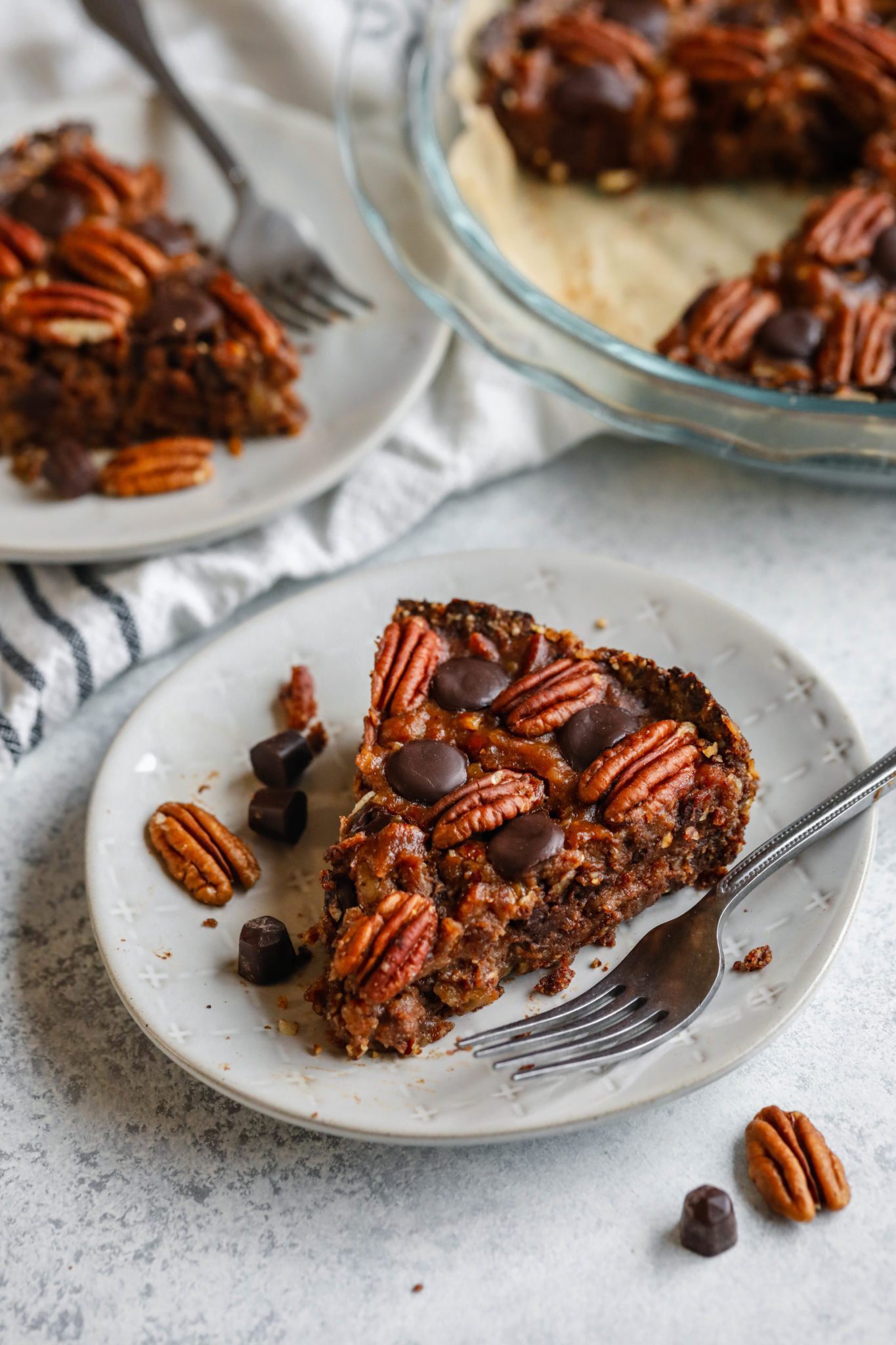 Vegan Dark Chocolate Pecan Pie served on a plate with a fork by Flora & Vino