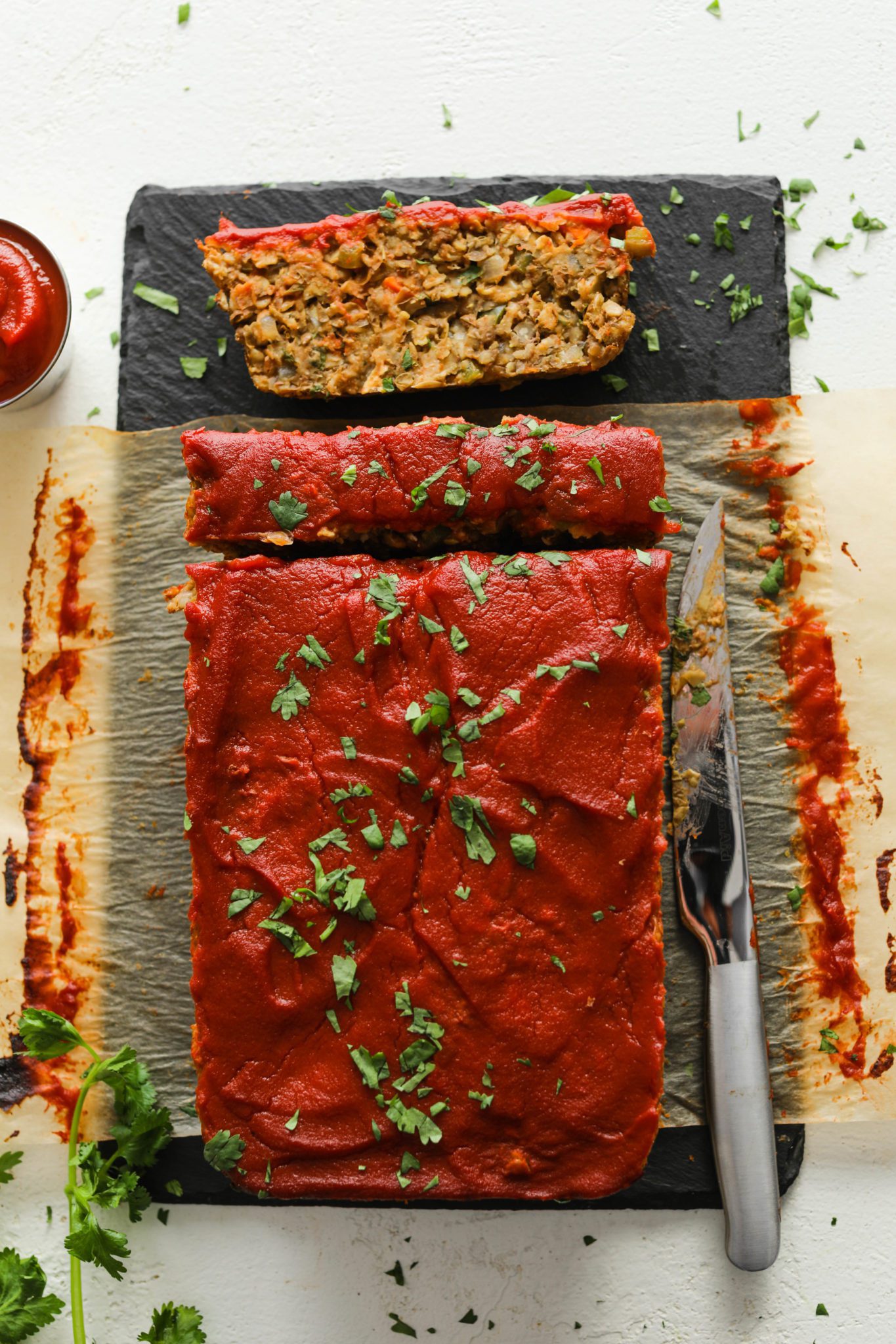 Vegan Lentil Oat Loaf served on a cutting board and sliced with a knife by Flora & Vino 