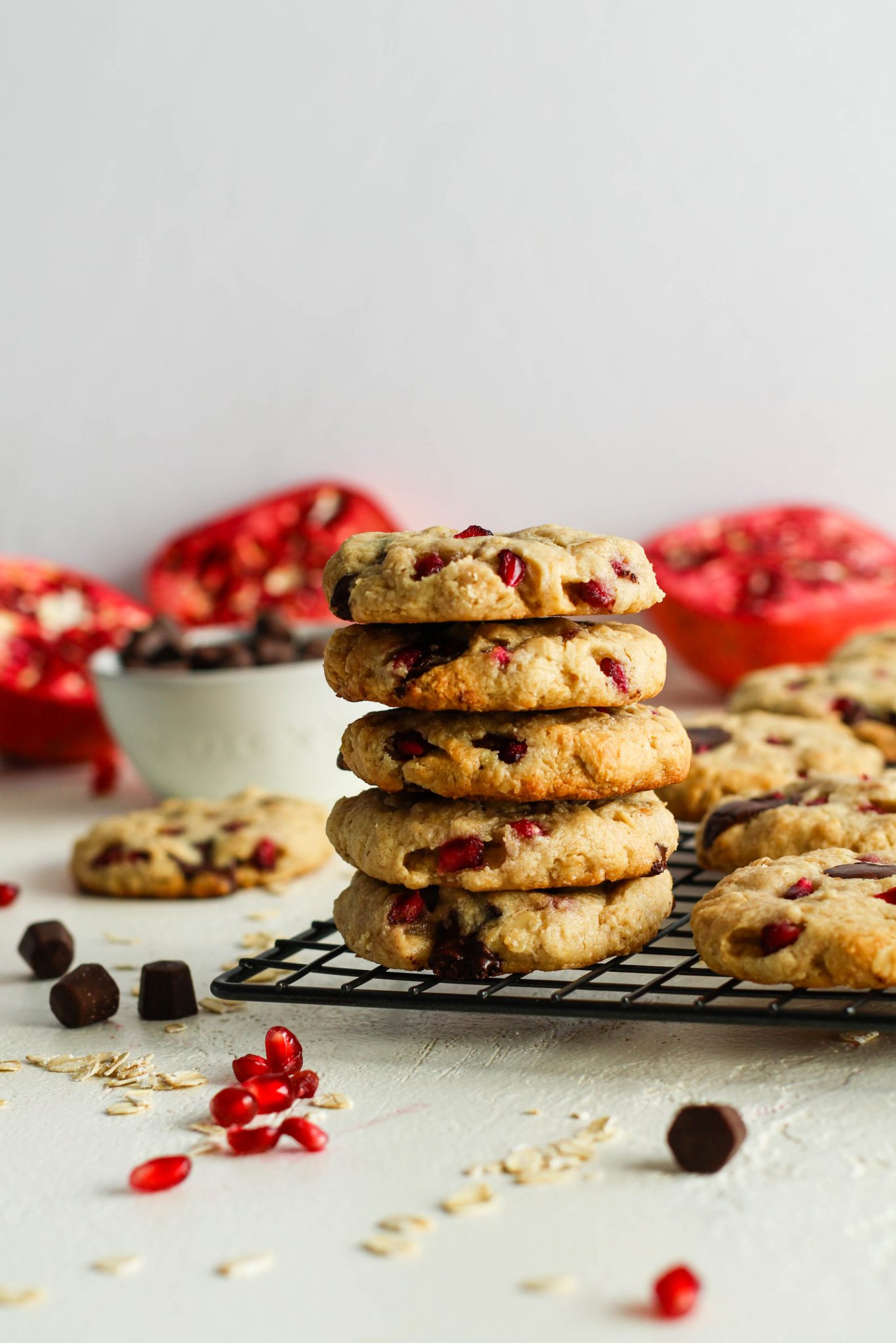 Pomegranate Oatmeal Chocolate Chip Cookies stacked on cooling raxk by Flora & Vino 