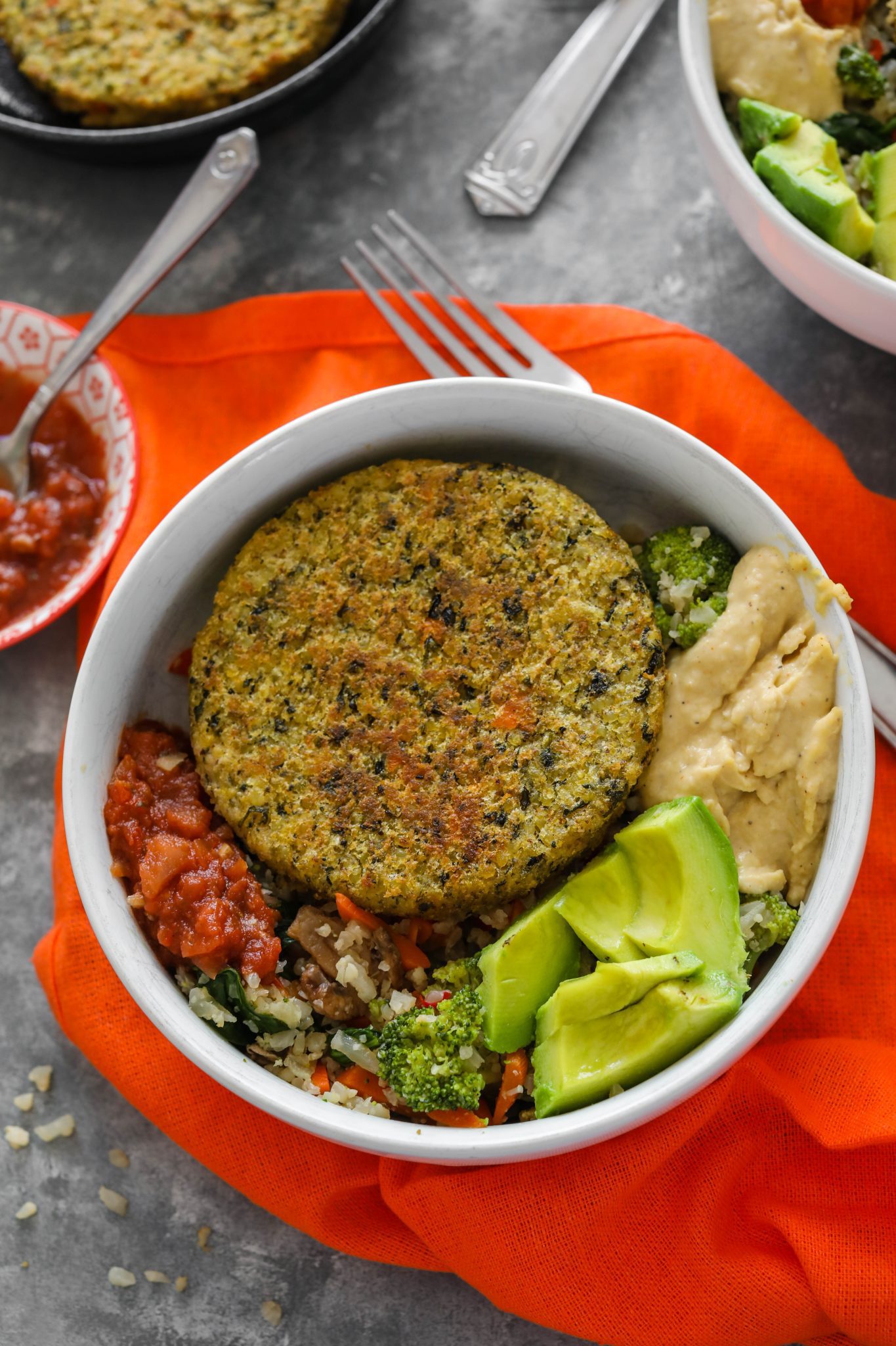 Cauliflower Rice Veggie Burger Bowl served in white bowl with avocado, hummus, and salsa