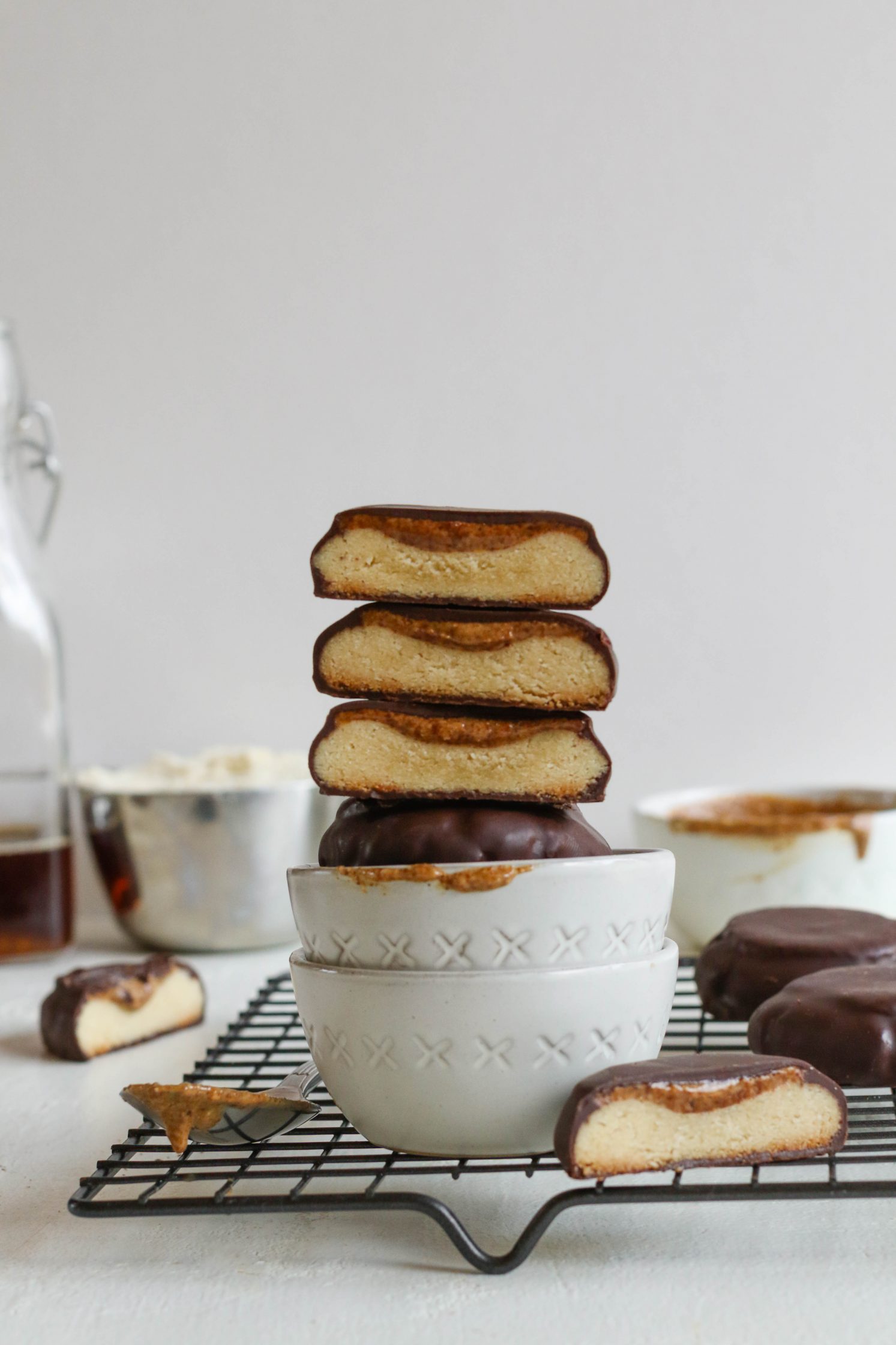 Vegan Almond Butter Tagalongs stacked in two white bowls on cooling rack 