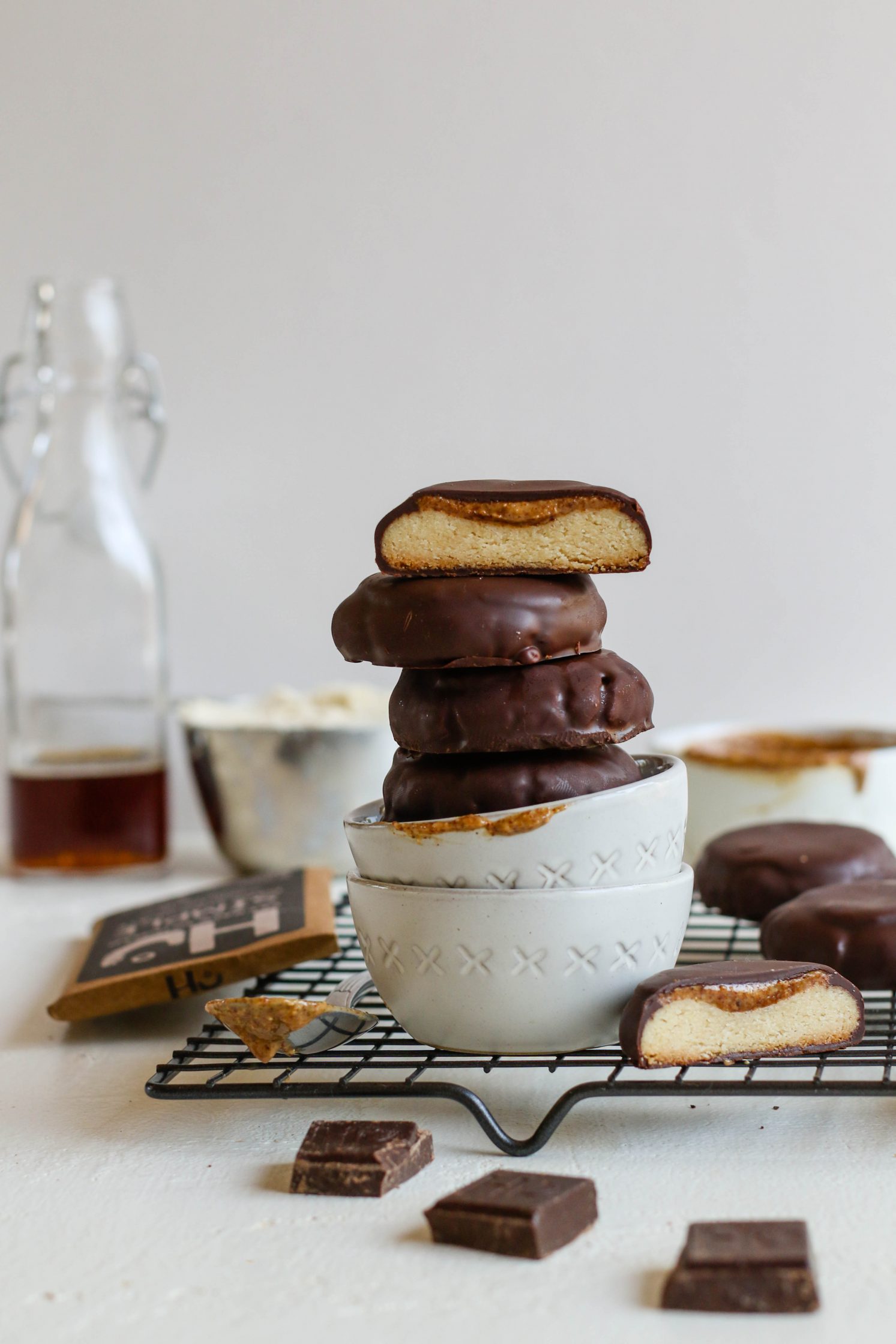 Vegan Almond Butter Tagalongs stacked in two white bowls on cooling rack 