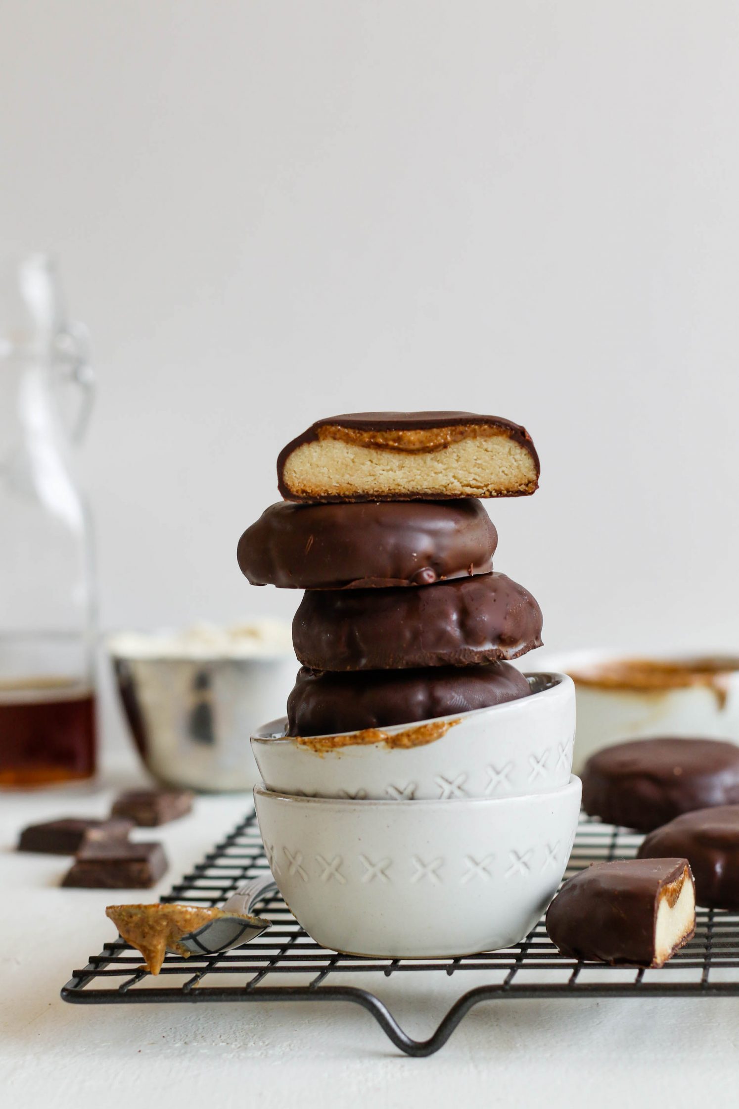 Vegan Almond Butter Tagalongs stacked in two white bowls on cooling rack 