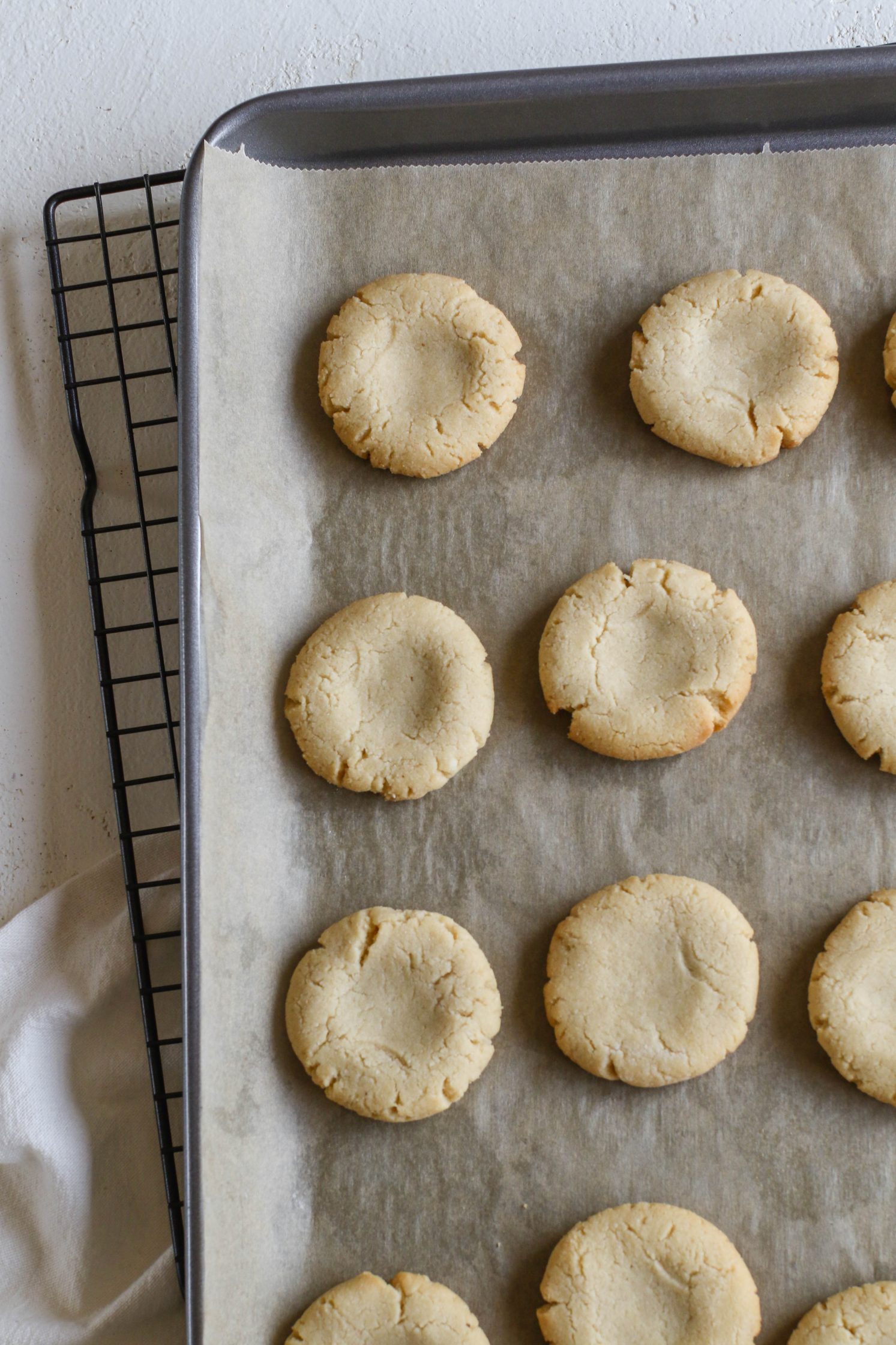 Almond Butter Tagalong Cookies baked on parchment lined baking sheet on top of cooling rack 