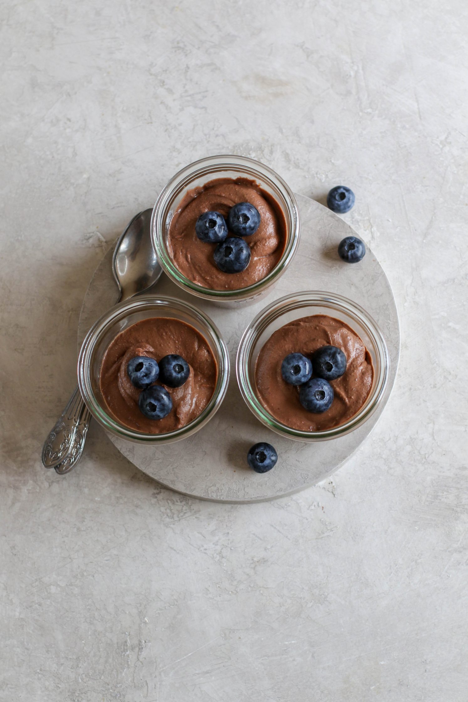 Black Bean Mousse served in mason jars with blueberries and spoons by Flora & Vino 