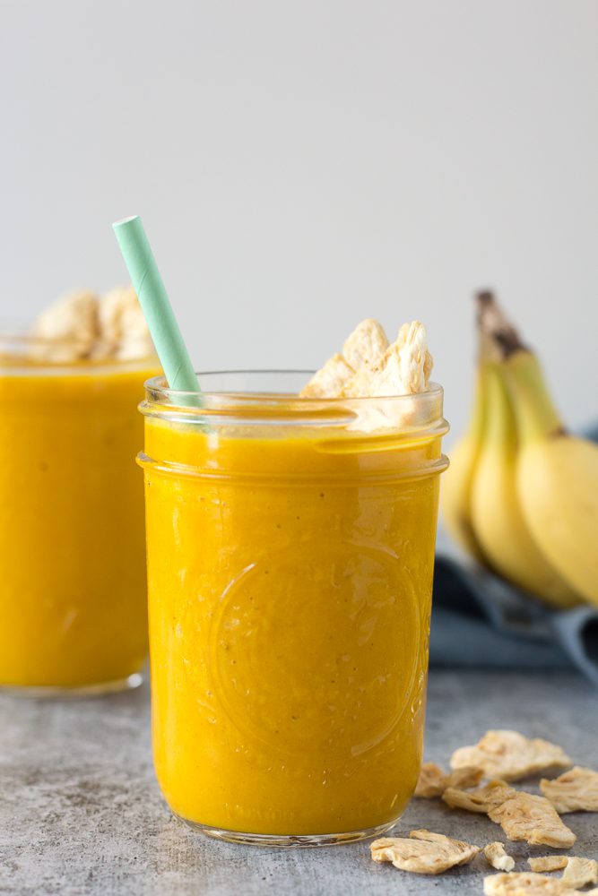 Pineapple Turmeric Tahini Shakes served in mason jars with straw topped with pineapple chips by Flora & Vino