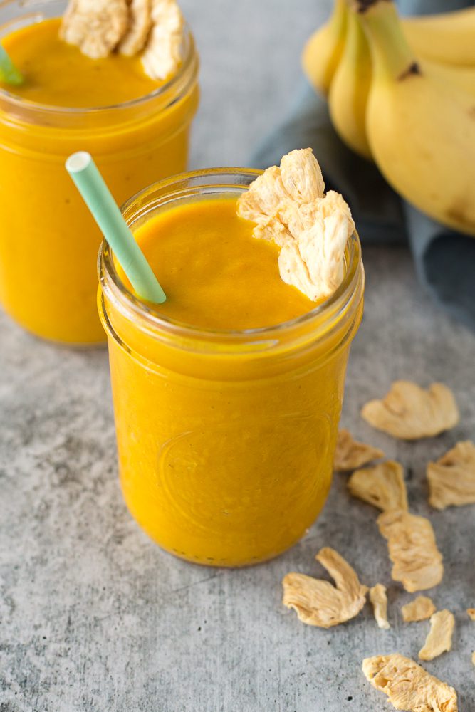 Pineapple Turmeric Tahini Shakes served in mason jars with straw topped with pineapple chips by Flora & Vino