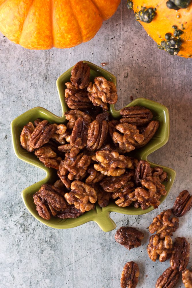 Easy Maple Spiced Nuts served in a bowl surrounded by gourds by Flora & Vino