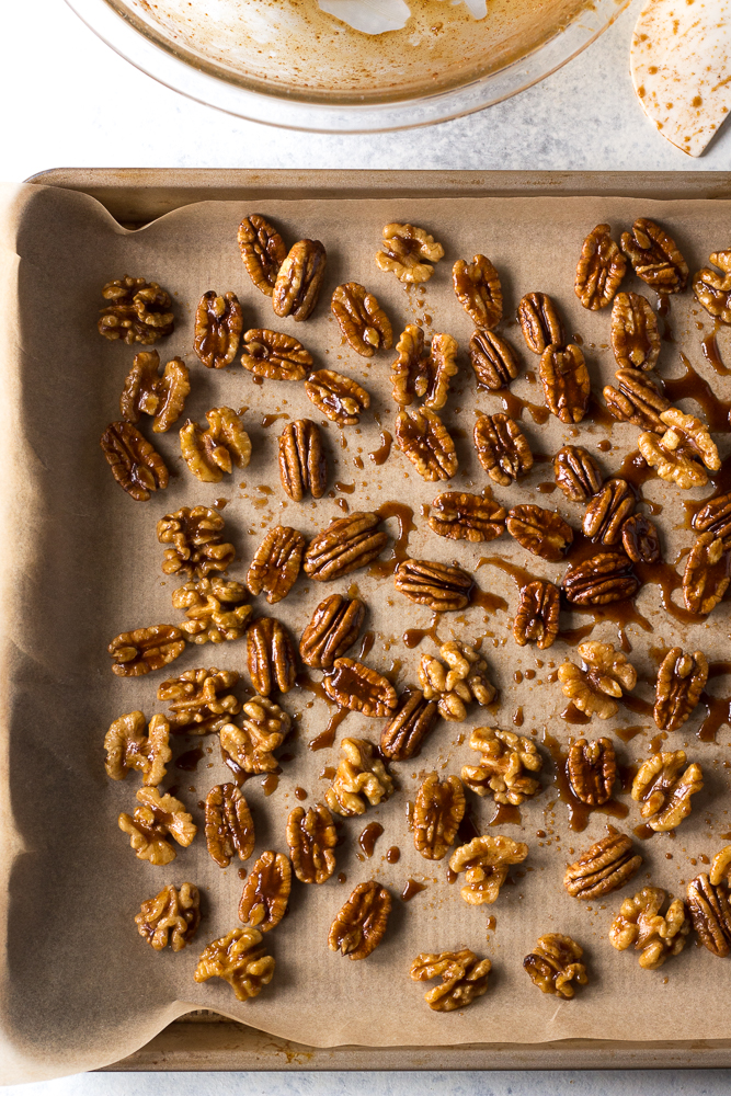Easy Maple Spiced Nuts on parchment lined baking sheet by Flora & Vino