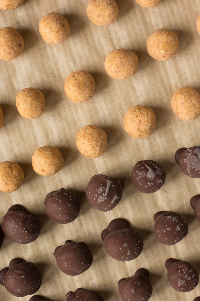 Vegan Peanut Butter Chocolate Balls on parchment paper by Flora & Vino