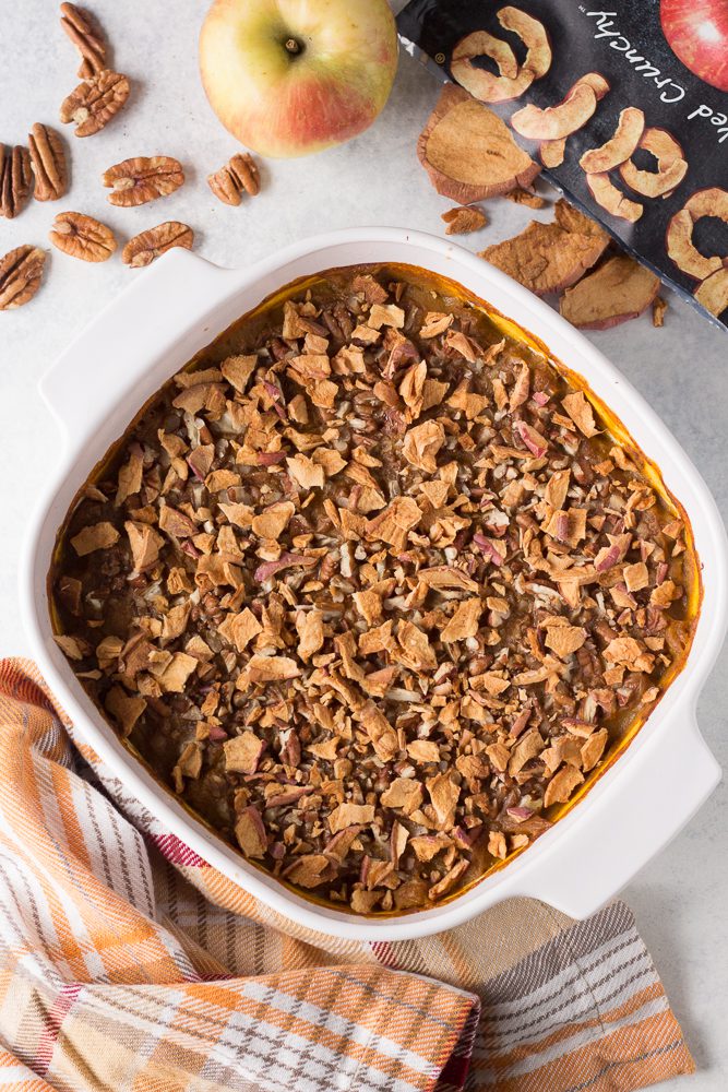 Pumpkin Apple Bake served in casserole dish with metal spoon topped with apple chips 