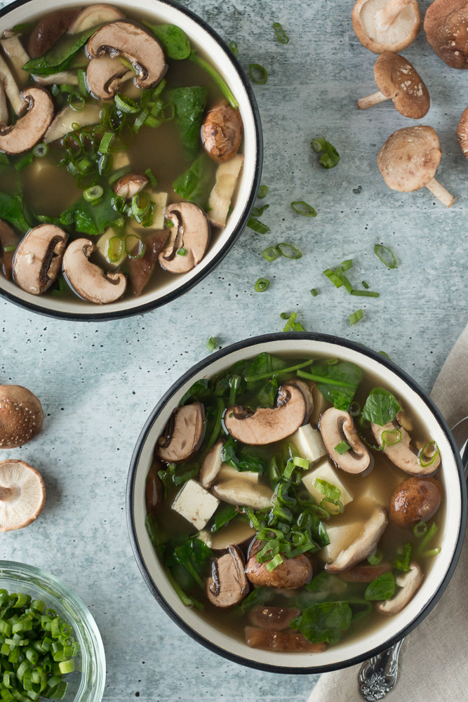 Miso Mushroom Soup served in bowls with scattered green onion and mushrooms by Flora & Vino 