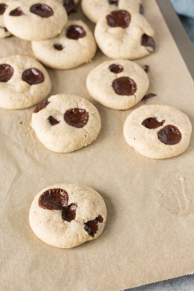Tahini Chocolate Chip Macademia Nut Cookies baked on parchment paper by Flora & Vino
