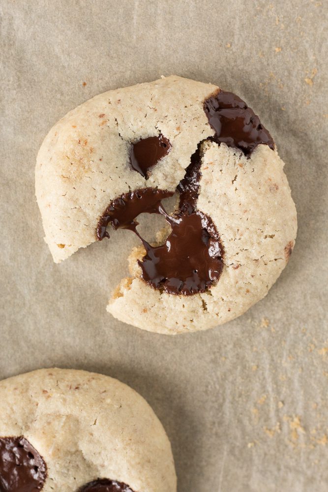 Tahini Chocolate Chip Macademia Nut Cookie broken in half by Flora & Vino