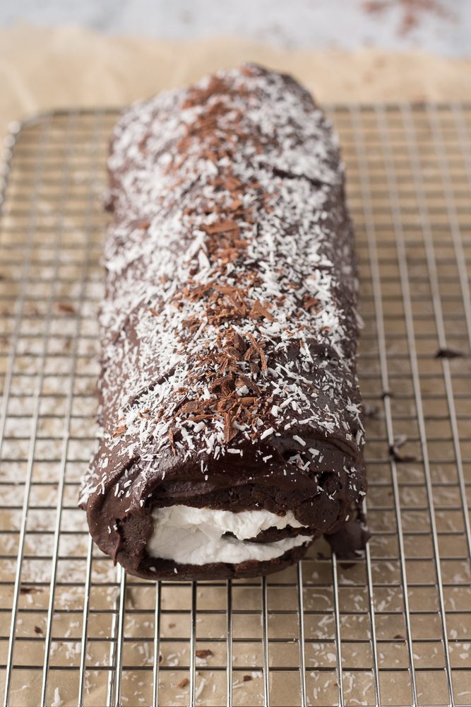 Vegan Dark Chocolate Swiss Roll topped with shredded coconut and chocolate by Flora & Vino