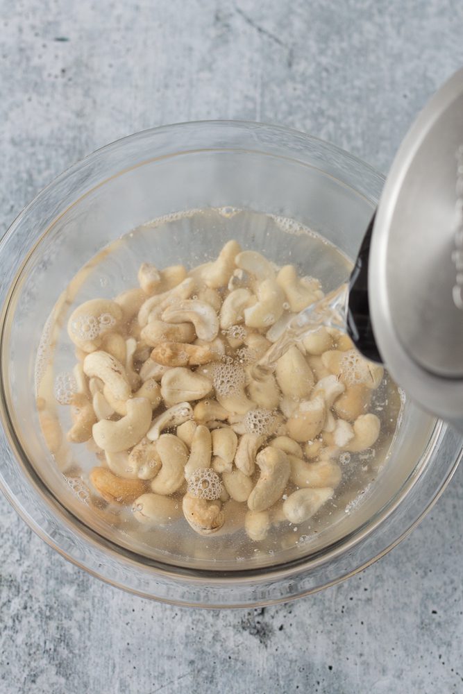 raw cashews in a bowl with hot water filling it up by Flora & Vino 