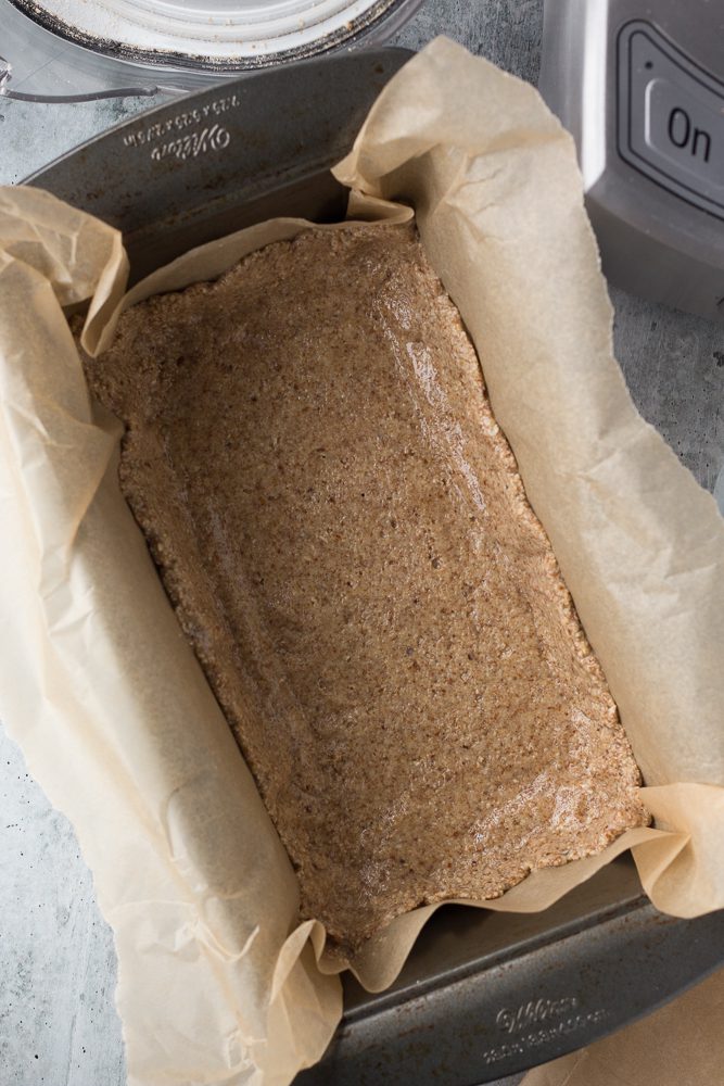 oat-almond crust pressed into parchment lined loaf pan by Flora & Vino 