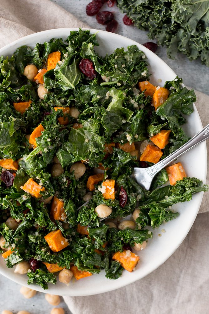 Warm Kale Salad served on plate with Citrus Tahini and fork by Flora & Vino