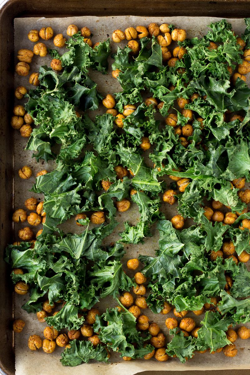 tandoori spiced chickpeas with kale on parchment lined baking sheet