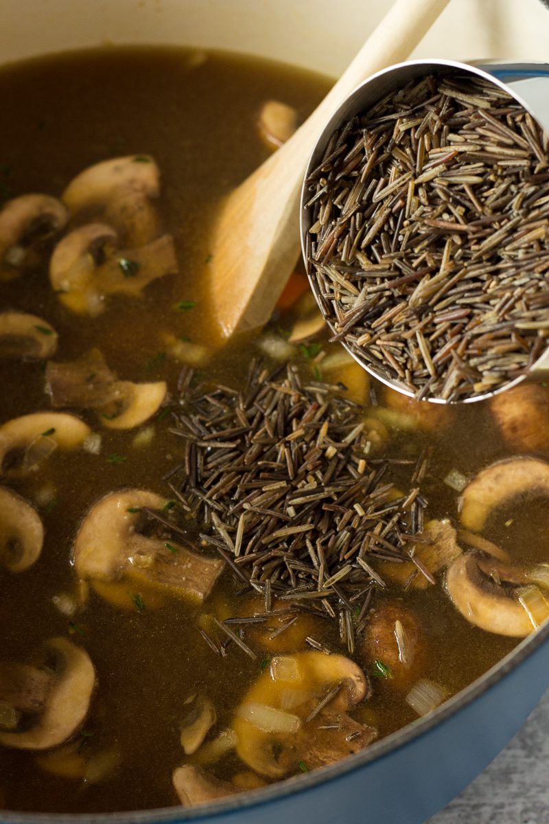 adding wild rice to vegetable broth by Flora & Vino