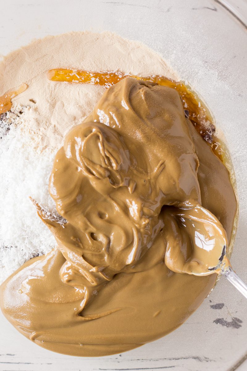 SunButter in bowl with spoon with everything granola bites ingredients