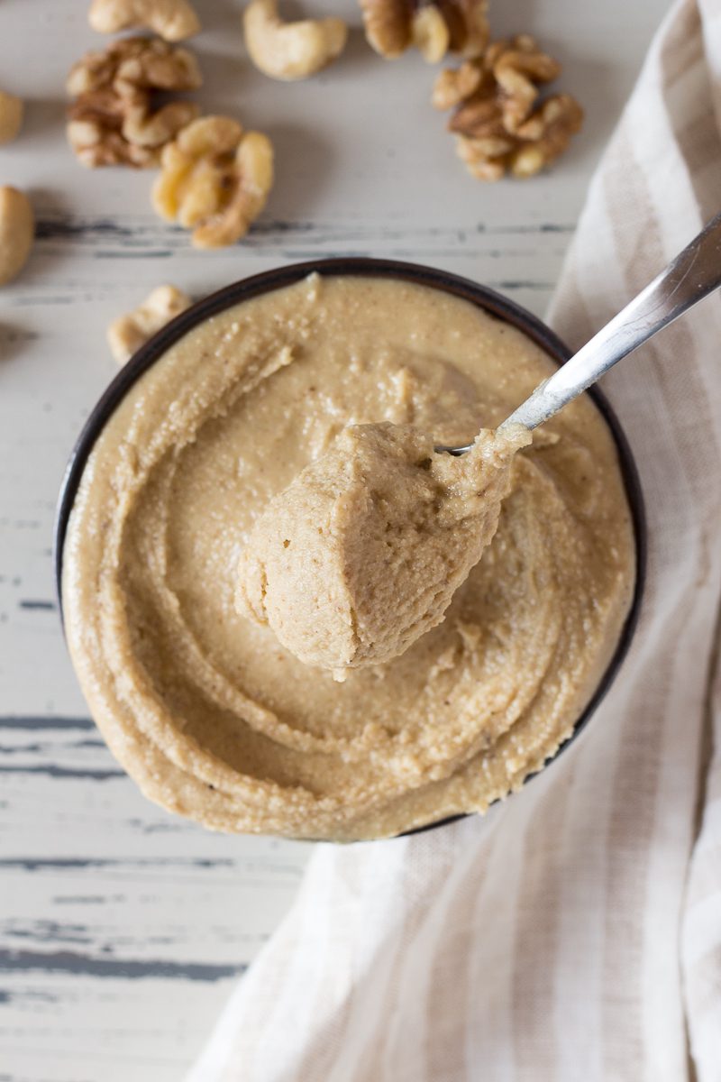 Raw Walnut Cashew Butter in a bowl with a spoon by Flora & Vino 