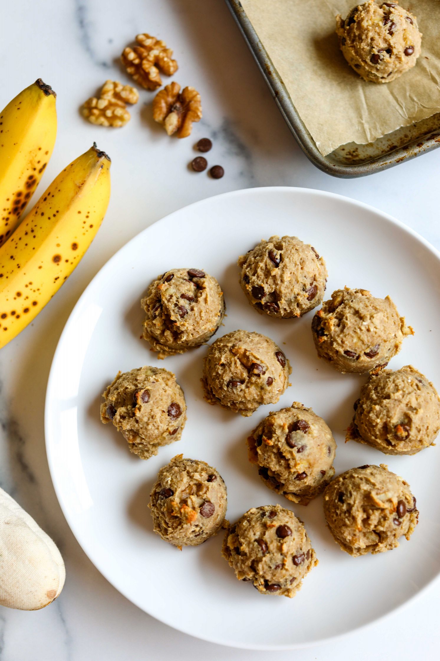 Banana Walnut Chocolate Chip Protein Cookies served on a plate with bananas on the side by Flora & Vino