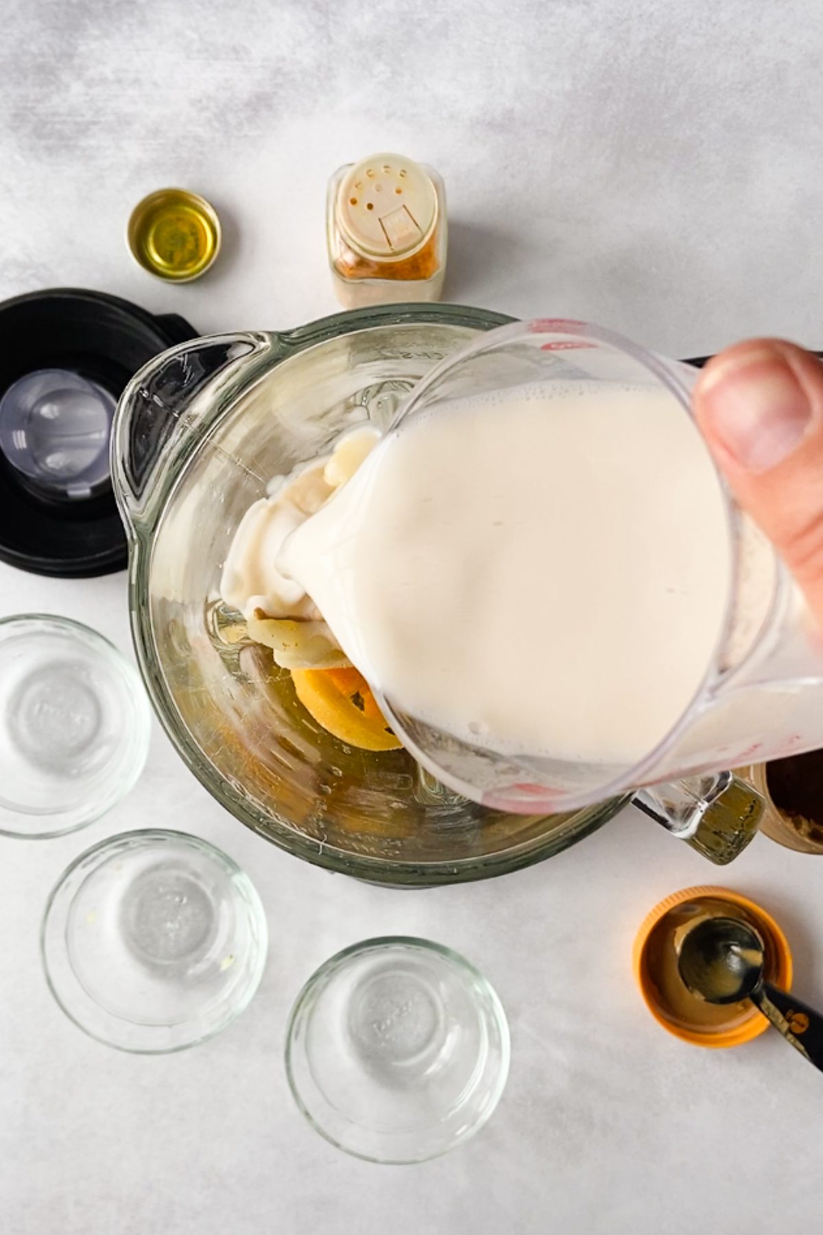 hand pouring milk into blender