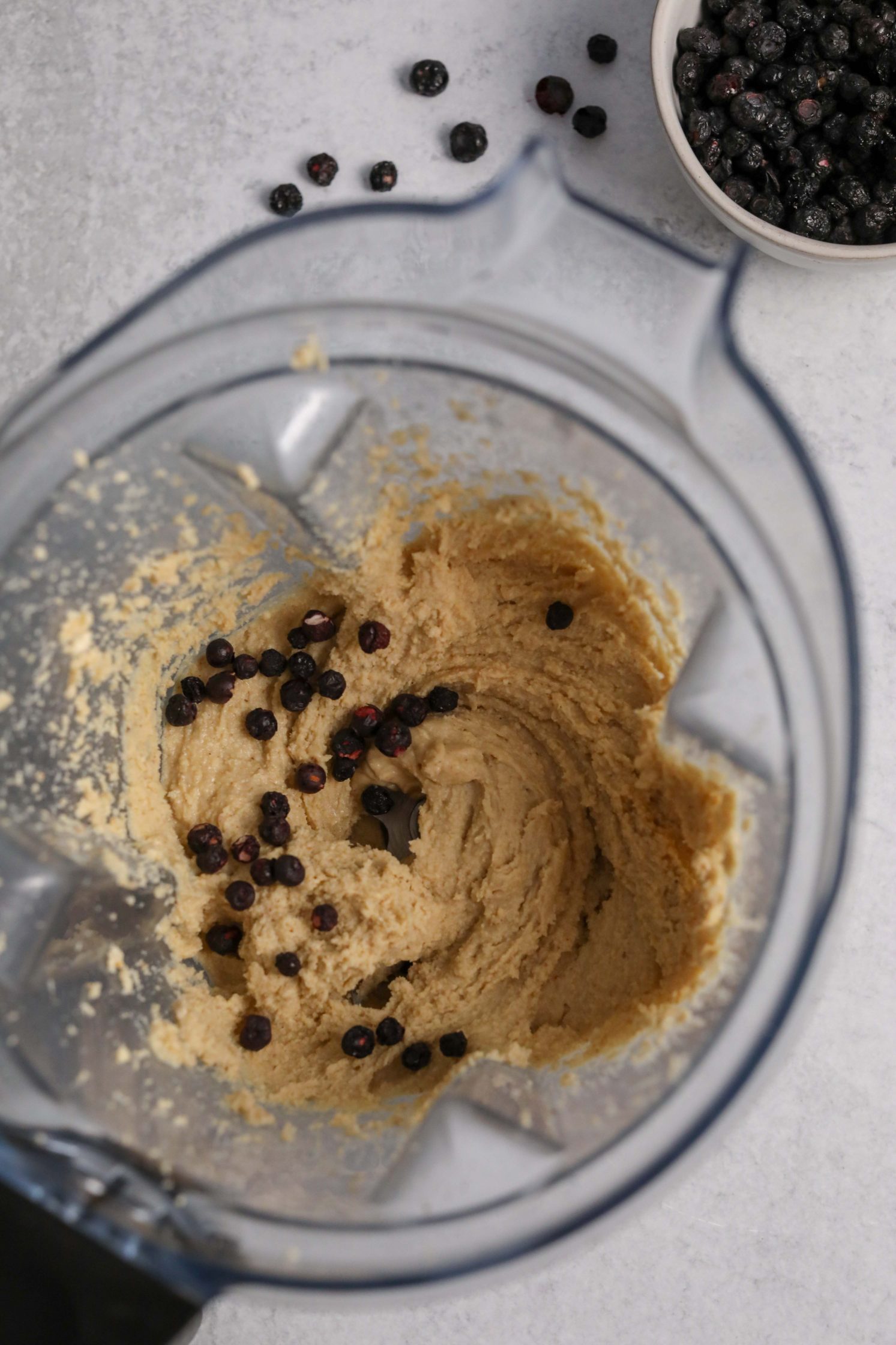 cashew butter in vitamix blender with freeze-dried blueberries added