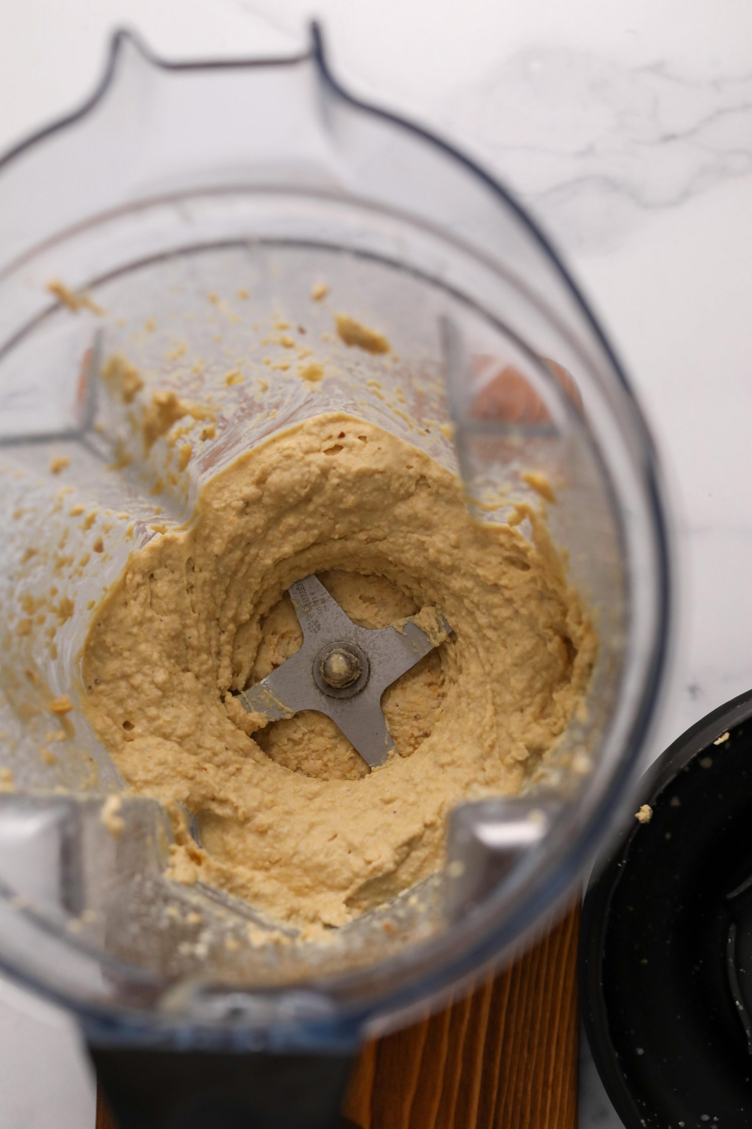 The Best Oil-Free Hummus blended in Vitamix on wooden board