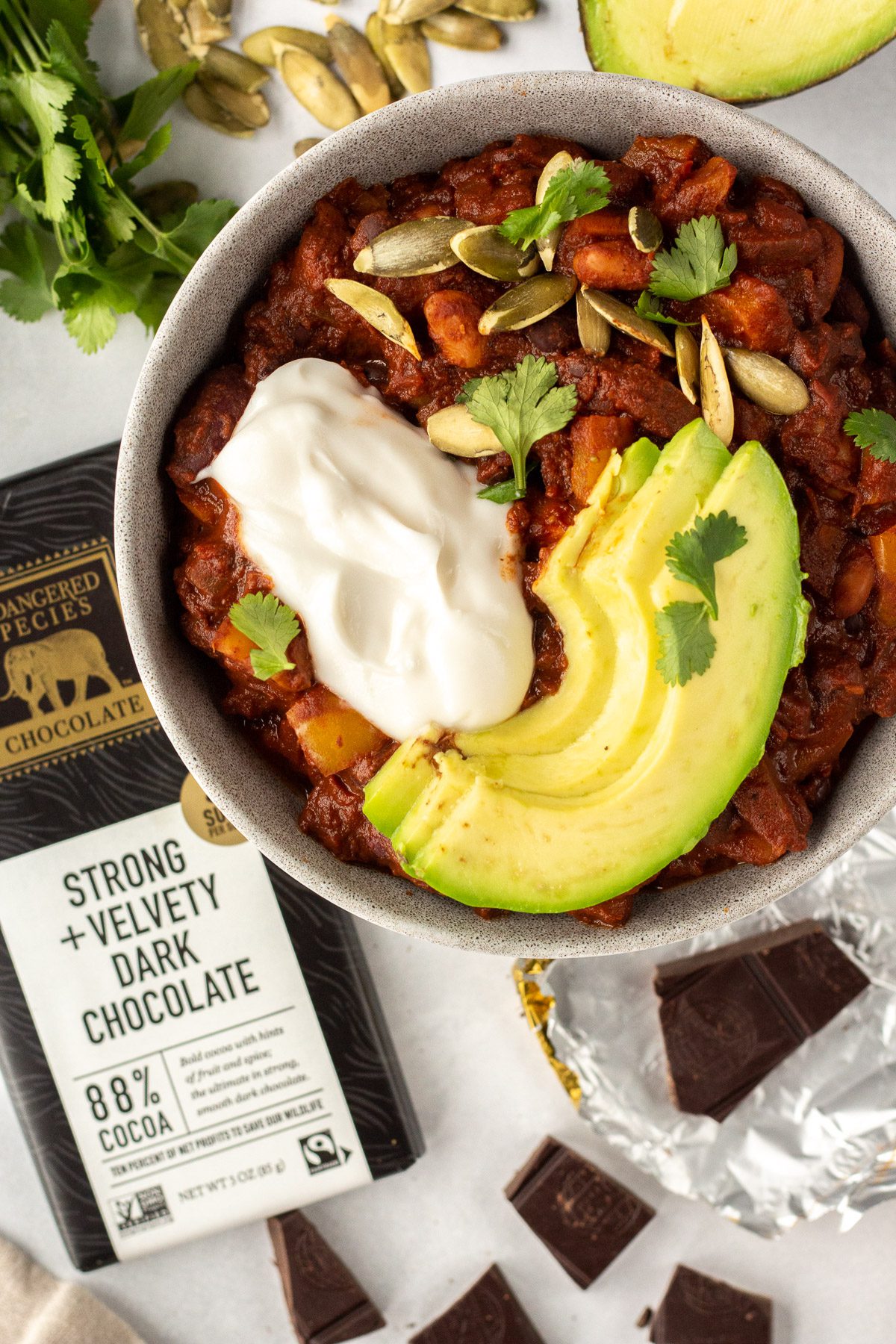 Vegan Chocolate Chili served in a bowl with avocado and yogurt with chocolate scattered by Flora & Vino