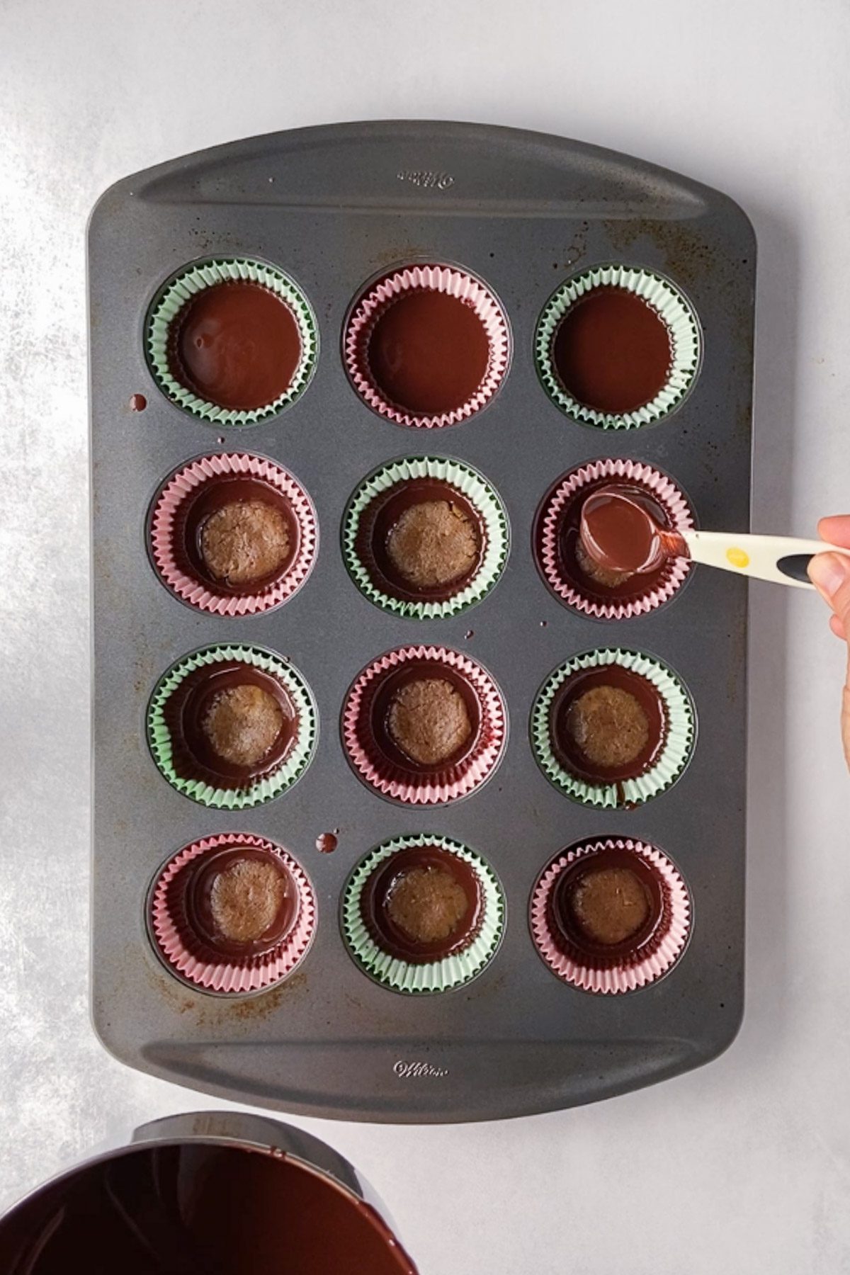 chocolate encasing SunButter caramel cups in muffin tin by Flora & Vino