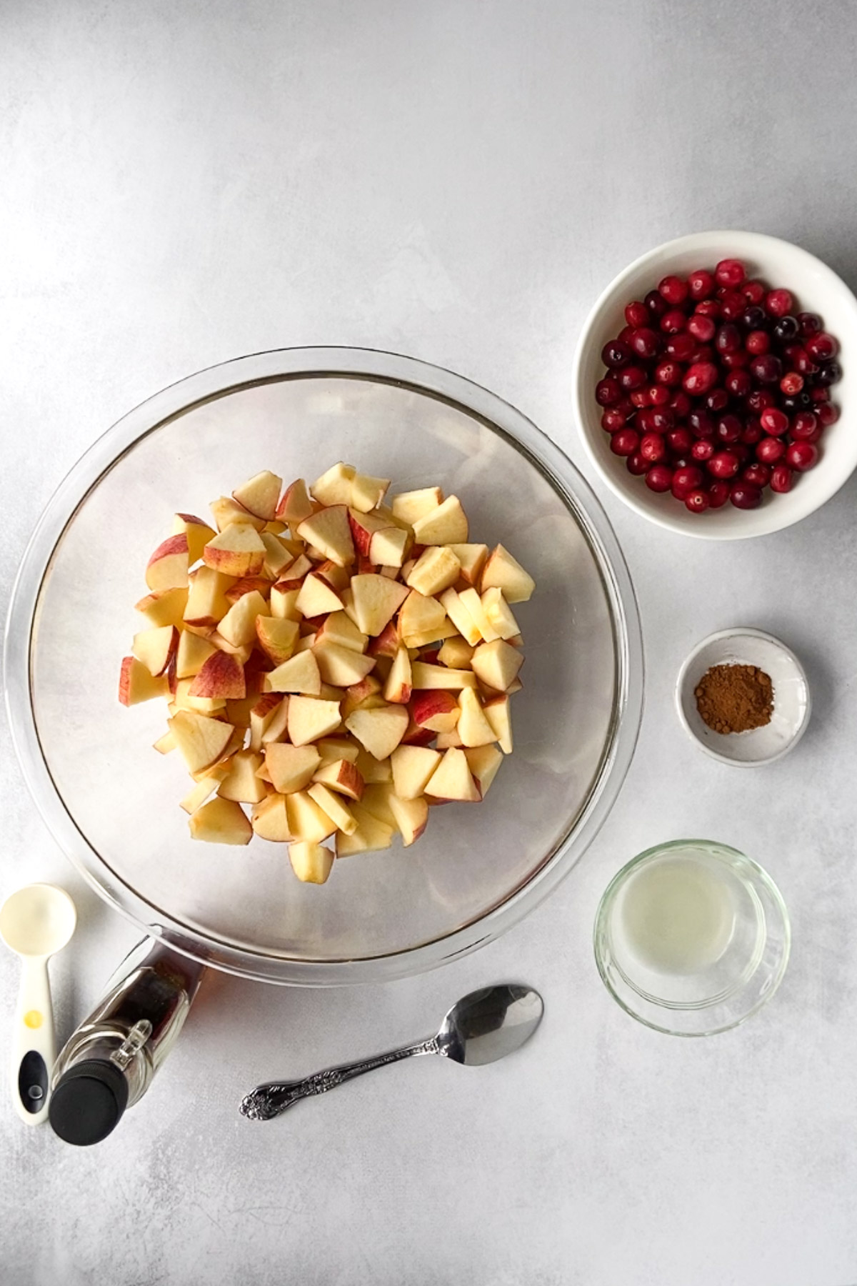 apples, cranberries, cinnamon, and maple syrup on board by Flora & vino