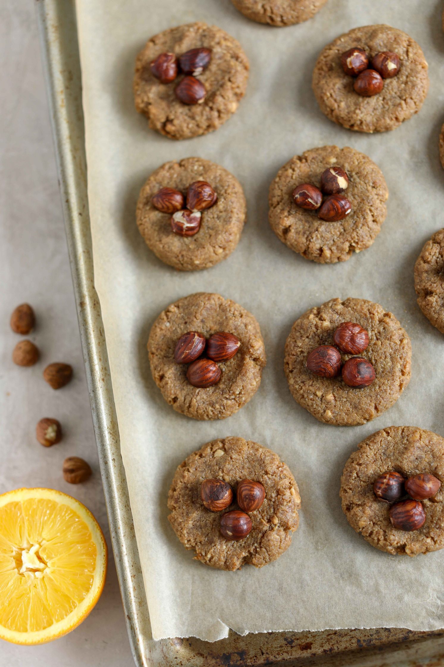 Orange Hazelnut Cookies baked on parchment lined baking sheet by Flora & Vino 