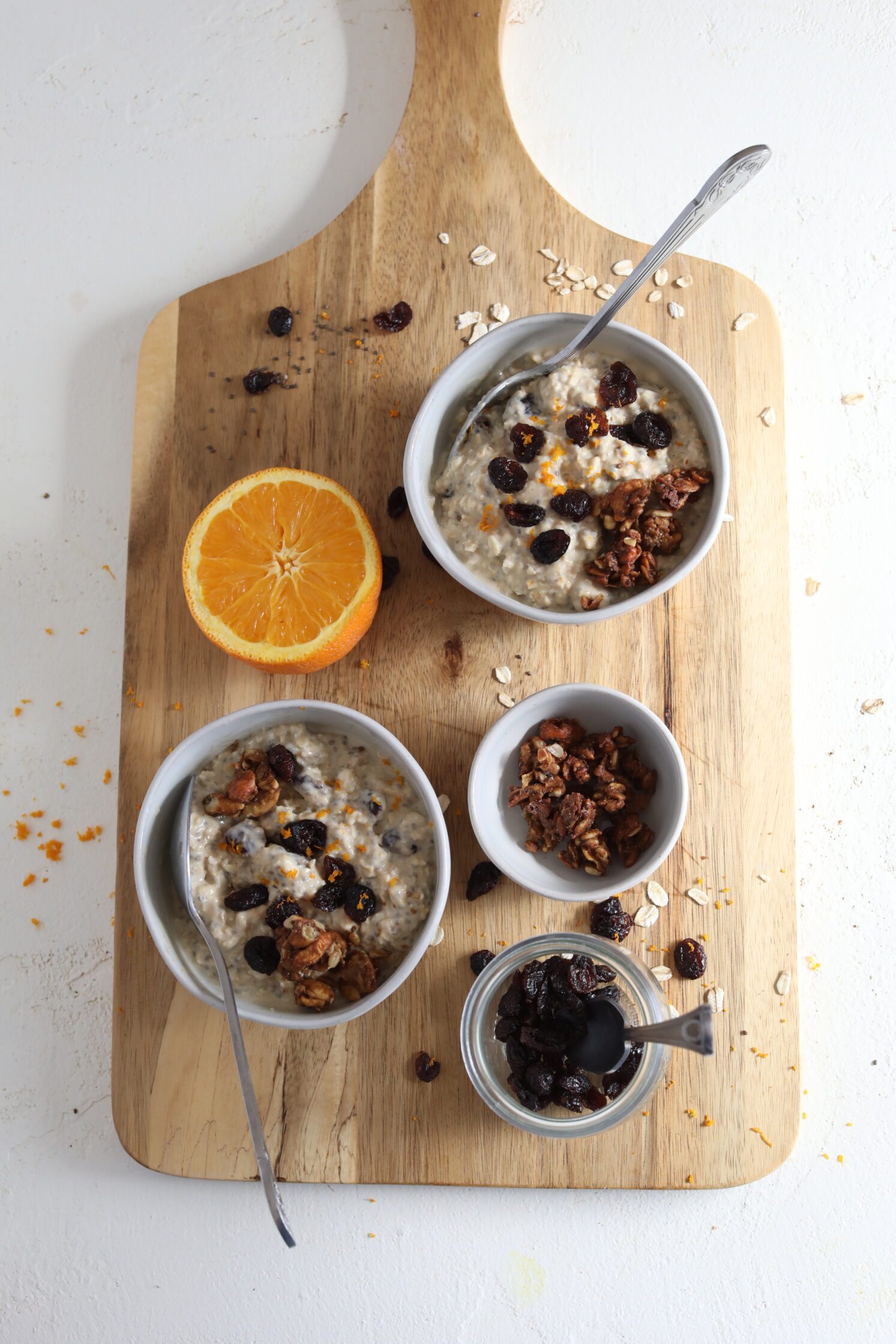 Orange Cranberry Overnight Oats served on wooden board by Flora & Vino