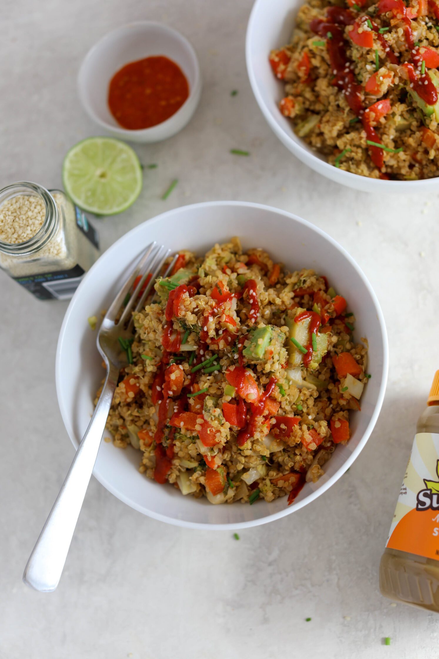 SunButter Quinoa Fried Rice served in bowls with a fork and sesame seeds by Flora & Vino 