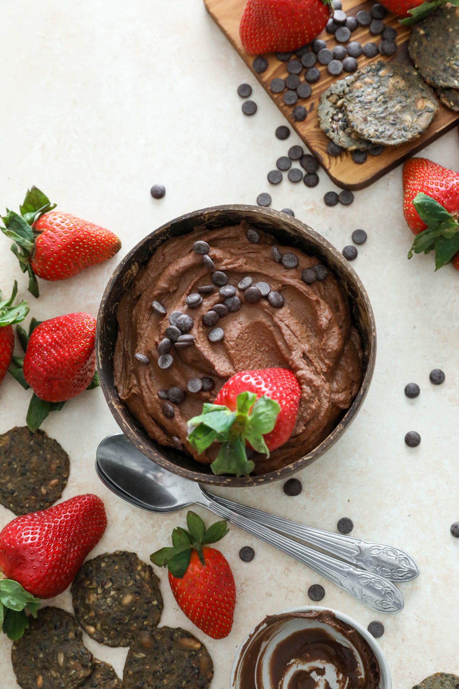 Vegan Brownie Batter Dip served in a bowl topped with dark chocolate chips and strawberries by Flora & Vino