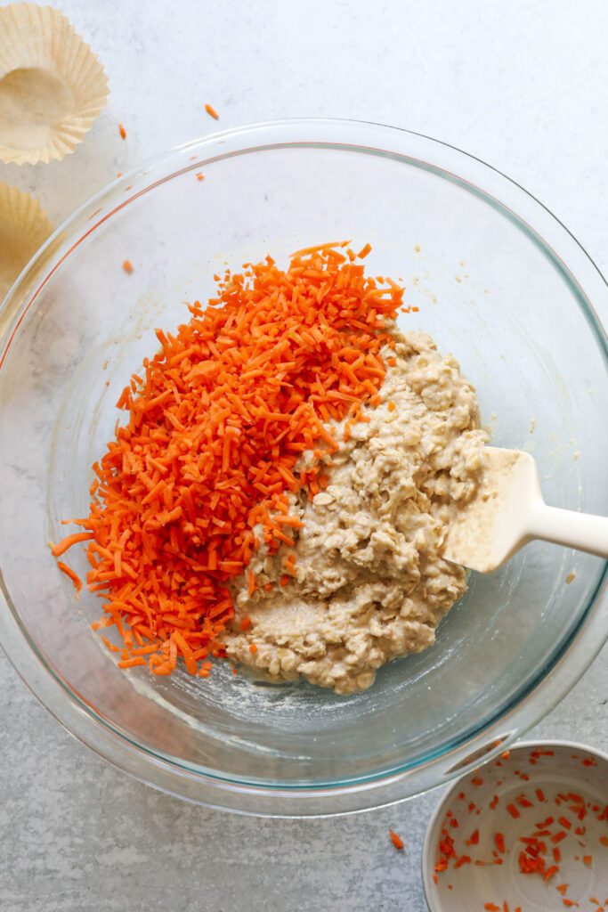 Carrot Cake Almond Flour Muffins batter with grated carrots mixed in with spatula 