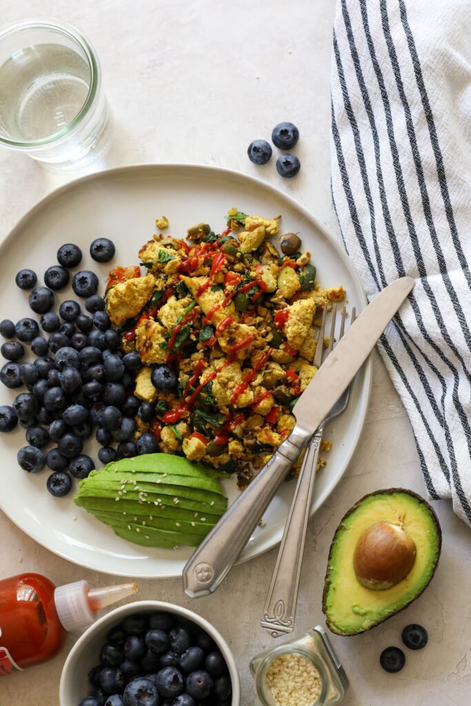 Easy Tofu Scramble Plate with blueberries and avocado and blueberries by Flora & Vino