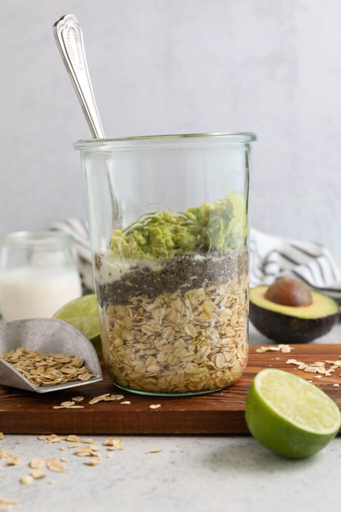 Key Lime Pie Overnight Oats ingredients unmixed in mason jar with spoon by Flora & Vino