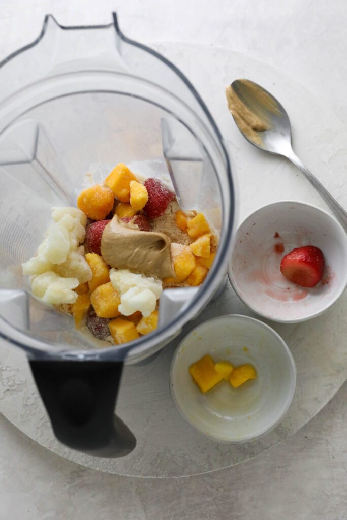 frozen mango, cauliflower, and strawberries in blender with cashew butter 