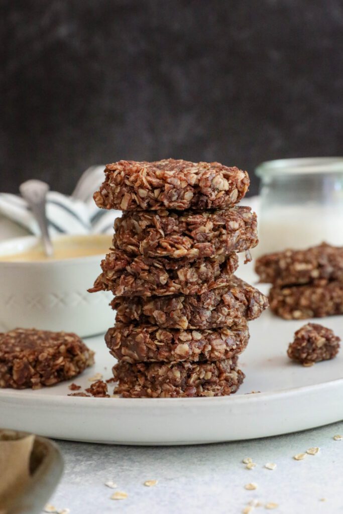 Chocolate Tahini No-Bake Cookies stacked on plate by Flora & Vino