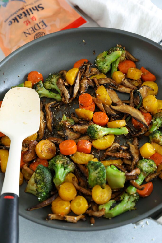 Sesame vegetables in pan with a spatula by Flora & Vino
