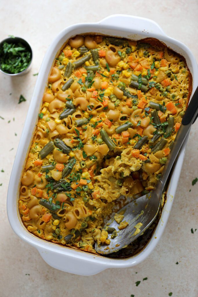 Chickpea Macaroni Casserole with serving spoon and parsley by Flora & Vino