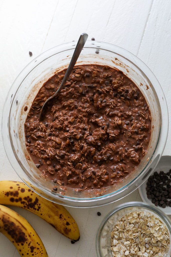 Chocolate Baked Oatmeal batter in a bowl with a spoon by Flora & Vino 