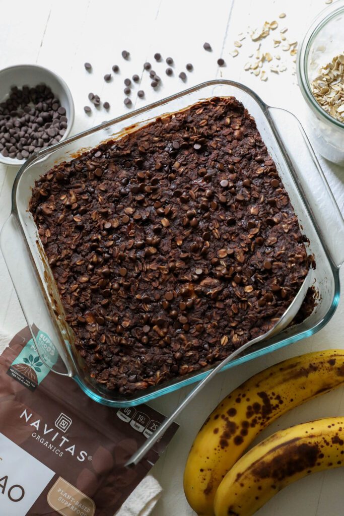 Chocolate Baked Oatmeal in baking dish with a spoon by Flora & Vino 