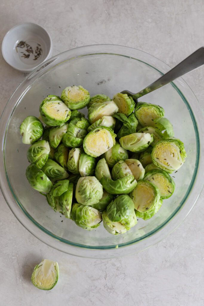 halved brussels sprouts in bowl with spoon by Flora & Vino