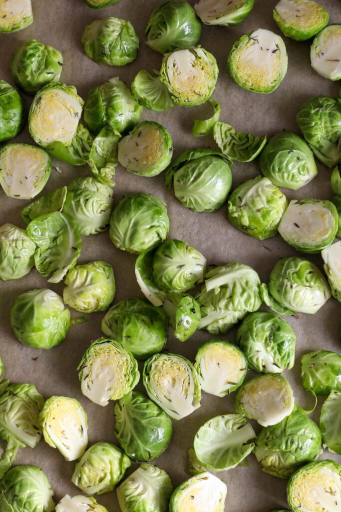 halved brussels sprouts on parchment lined baking sheet by Flora & Vino