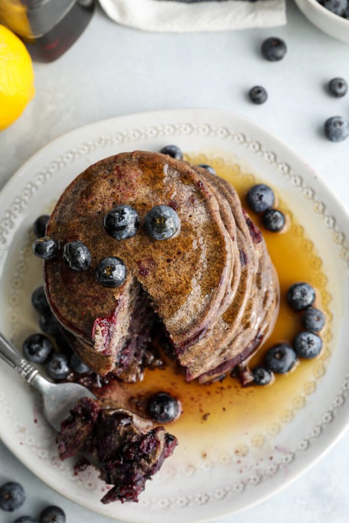 Blueberry Buckwheat Pancakes stacked with fork by Flora & Vino